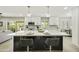Open kitchen featuring white cabinets, a large black island with seating, and modern pendant lighting at 10538 E Gold Dust Cir, Scottsdale, AZ 85258