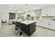Modern kitchen with white cabinets, black island with seating, pendant lighting, and stainless steel appliances at 10538 E Gold Dust Cir, Scottsdale, AZ 85258