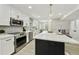 Bright kitchen with stainless steel appliances, white cabinets, and a black kitchen island at 10538 E Gold Dust Cir, Scottsdale, AZ 85258