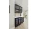 Wet bar featuring black cabinets, wine fridge, quartz countertop, and views of the patio at 10538 E Gold Dust Cir, Scottsdale, AZ 85258