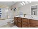 Bright bathroom features a double sink vanity with wood cabinets and tile flooring at 11521 E Quintana Ave, Mesa, AZ 85212