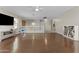 Bright bonus room featuring wood floors, ceiling fan, media console, and railing at 11521 E Quintana Ave, Mesa, AZ 85212