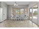 Bright dining area features a bay window, white table, and sliding glass door to patio at 11521 E Quintana Ave, Mesa, AZ 85212