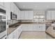 Well-lit kitchen boasts white cabinets, granite countertops, stainless steel appliances, and tile backsplash at 11521 E Quintana Ave, Mesa, AZ 85212