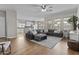 Bright living room featuring a large sectional sofa, wood flooring, and an open layout to the kitchen at 11521 E Quintana Ave, Mesa, AZ 85212
