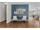 Inviting sitting area with accent wall, modern art, hardwood floors and two comfortable armchairs at 11521 E Quintana Ave, Mesa, AZ 85212