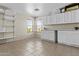 Versatile room features cabinets, shelves, tile flooring, counter, and large window at 11521 E Quintana Ave, Mesa, AZ 85212