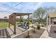 An inviting backyard featuring a pergola, fire pit, rock landscaping, lush green grass, and a built-in grill at 1321 W 14Th St, Tempe, AZ 85281