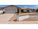 Traditional home featuring a two-car garage, neutral paint, and a low brick wall in the front yard at 136 E San Angelo Ave, Gilbert, AZ 85234