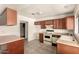 Spacious kitchen features oak cabinetry, white countertops, tile flooring, and modern appliances in a well-lit space at 136 E San Angelo Ave, Gilbert, AZ 85234