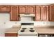 View of kitchen featuring an older-style white oven range and oak cabinets with white countertops at 136 E San Angelo Ave, Gilbert, AZ 85234