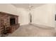 Open living room featuring a red brick fireplace and neutral carpeting at 136 E San Angelo Ave, Gilbert, AZ 85234