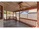Covered patio features a ceiling fan, concrete flooring, and a wooden railing, perfect for outdoor relaxation at 136 E San Angelo Ave, Gilbert, AZ 85234