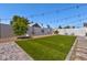 Landscaped backyard featuring artificial grass, stone pavers, and charming string lights at 13614 N 38Th Pl, Phoenix, AZ 85032