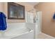 Bright bathroom features a tub, glass-enclosed shower and shuttered window at 16259 W Papago St, Goodyear, AZ 85338