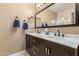 Bathroom showcasing double sinks with marble countertops, dark cabinetry, and a glass-enclosed shower at 16259 W Papago St, Goodyear, AZ 85338