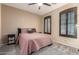 This comfortable bedroom features a ceiling fan, shuttered window, and neutral color palette at 16259 W Papago St, Goodyear, AZ 85338
