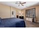 This cozy bedroom features a ceiling fan, shuttered window, wood floor and neutral color palette at 16259 W Papago St, Goodyear, AZ 85338
