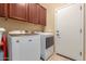 Well-lit laundry room with front load washer and dryer and above storage cabinets at 16259 W Papago St, Goodyear, AZ 85338