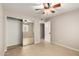 Bright bedroom featuring ceiling fan, tile floor, mirrored closet, and white door frame at 19601 N 7Th St # 1022, Phoenix, AZ 85024