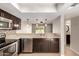 This modern kitchen offers dark cabinetry, stainless steel appliances, and a breakfast bar with pendant lights at 19601 N 7Th St # 1022, Phoenix, AZ 85024