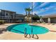 Community pool surrounded by lush landscaping and nearby condos, creating a resort-like atmosphere at 19601 N 7Th St # 1022, Phoenix, AZ 85024