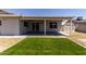 Spacious backyard featuring a covered patio, lush green lawn, and privacy fence at 2233 W Oraibi Dr, Phoenix, AZ 85027
