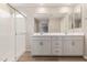 Modern bathroom featuring a double sink vanity, framed mirror and a glass enclosed shower at 22863 N 183Rd Dr, Surprise, AZ 85387
