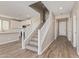 Inviting entryway featuring wood-look tile floors and a staircase with white railing, leading to an open-concept kitchen at 22863 N 183Rd Dr, Surprise, AZ 85387