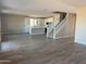 Open-concept living space with wood-look floors seamlessly connecting the living area, kitchen, and staircase at 22863 N 183Rd Dr, Surprise, AZ 85387