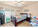 Cozy bedroom featuring wood-look floors, ceiling fan, and decorative wall art at 244 N Rock St, Gilbert, AZ 85234