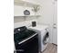 Well-lit laundry room with modern black and white appliances and shelving at 244 N Rock St, Gilbert, AZ 85234