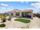 Spacious backyard with desert landscaping, a covered patio and synthetic grass at 26824 W Ponderosa Ln, Buckeye, AZ 85396
