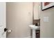 Pedestal sink in a half bathroom with dark hardware at 26824 W Ponderosa Ln, Buckeye, AZ 85396