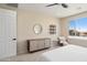 Bright, carpeted bedroom features large window with scenic view, stylish furniture, and a ceiling fan at 26824 W Ponderosa Ln, Buckeye, AZ 85396