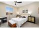Bedroom with large window, ceiling fan, modern furnishings, and bench at the foot of bed at 26824 W Ponderosa Ln, Buckeye, AZ 85396