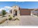 Inviting single-Gathering home featuring a stucco facade, a tile roof, and a well-manicured desert landscape in front at 26824 W Ponderosa Ln, Buckeye, AZ 85396