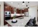 A gourmet kitchen with granite countertops, a central island, and stainless steel appliances and dark wood cabinets at 26824 W Ponderosa Ln, Buckeye, AZ 85396