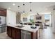 Open concept kitchen with stainless steel appliances, dark wood cabinets, granite countertops, and tile flooring at 26824 W Ponderosa Ln, Buckeye, AZ 85396