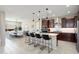 Open-concept kitchen flows to dining area, featuring granite countertops, dark cabinets, and stainless appliances at 26824 W Ponderosa Ln, Buckeye, AZ 85396