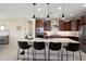 Kitchen features granite countertops, stainless appliances, dark cabinetry, and pendant lighting over a breakfast bar at 26824 W Ponderosa Ln, Buckeye, AZ 85396