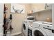 Bright laundry room featuring white washer and dryer, storage shelving, and modern decor at 26824 W Ponderosa Ln, Buckeye, AZ 85396