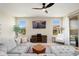 Comfortable living room with a ceiling fan, large windows, and sliding glass doors to the outside at 26824 W Ponderosa Ln, Buckeye, AZ 85396