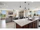 An open-concept kitchen and living room layout with stainless appliances, granite countertops, and seamless flow at 26824 W Ponderosa Ln, Buckeye, AZ 85396