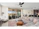 Bright living room featuring sliding glass doors, comfortable seating, ceiling fan, and a stylish area rug at 26824 W Ponderosa Ln, Buckeye, AZ 85396