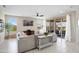 Spacious living room with modern furnishings, bright windows, and a sliding glass door to the outside at 26824 W Ponderosa Ln, Buckeye, AZ 85396