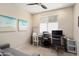 Bright office space featuring a gray couch, multiple desks, rolling chairs, and wall art at 26824 W Ponderosa Ln, Buckeye, AZ 85396