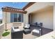 Relaxing covered patio with stylish outdoor seating and a view of the landscaped backyard with a desert aesthetic at 26824 W Ponderosa Ln, Buckeye, AZ 85396