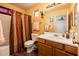 A warm, cheerful bathroom features a shower/tub combo and wooden vanity with a white countertop sink at 2721 N 107Th Dr, Avondale, AZ 85392