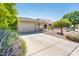 Beautiful home featuring a manicured front yard with mature trees, colorful landscaping, and a large driveway at 2721 N 107Th Dr, Avondale, AZ 85392